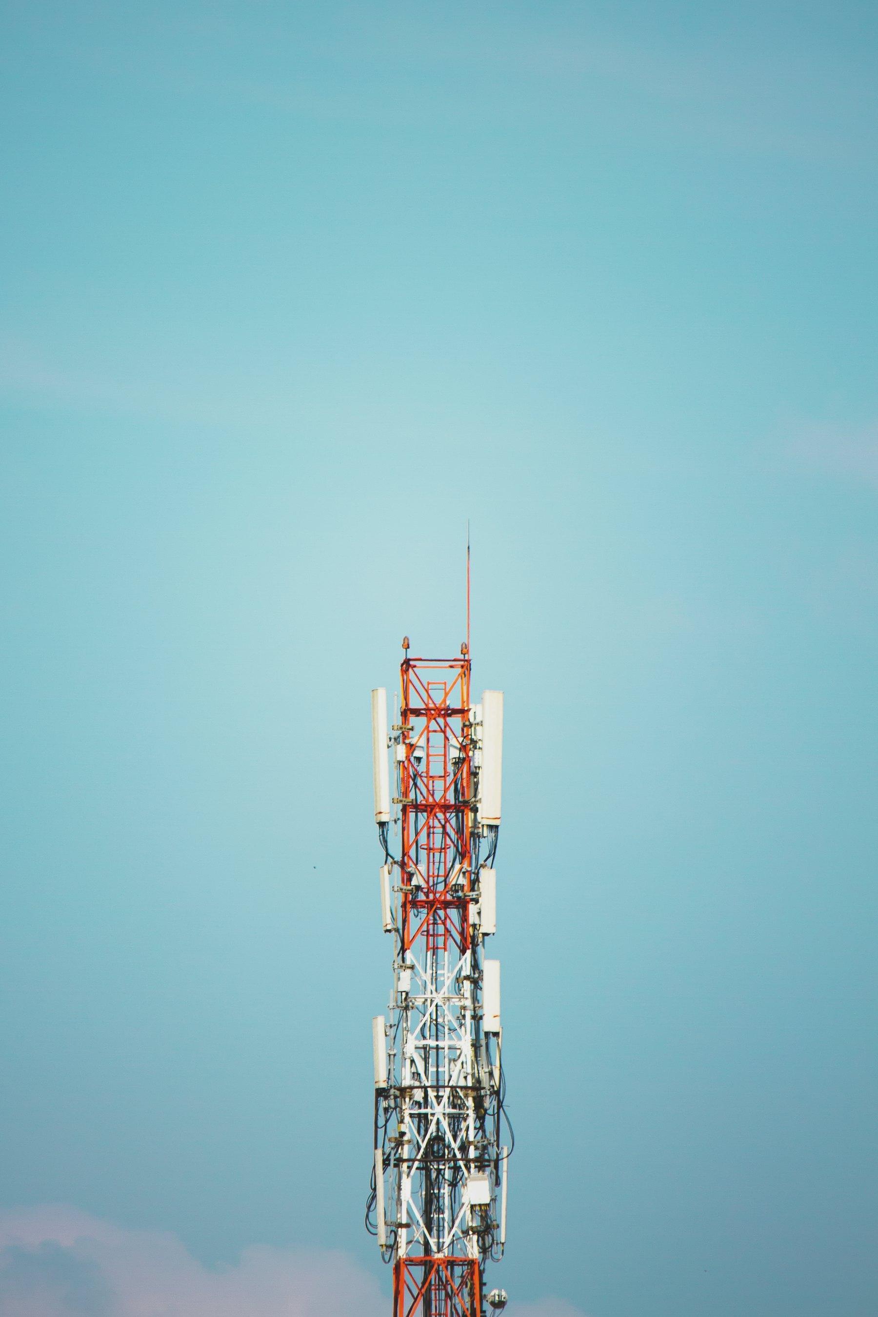 Communications tower with antennas against a blue sky