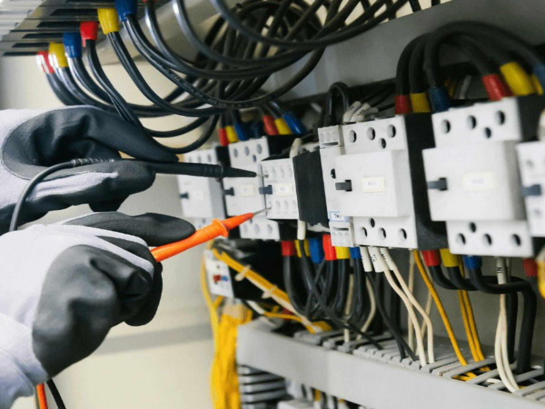 Electrician testing wiring in a breaker panel